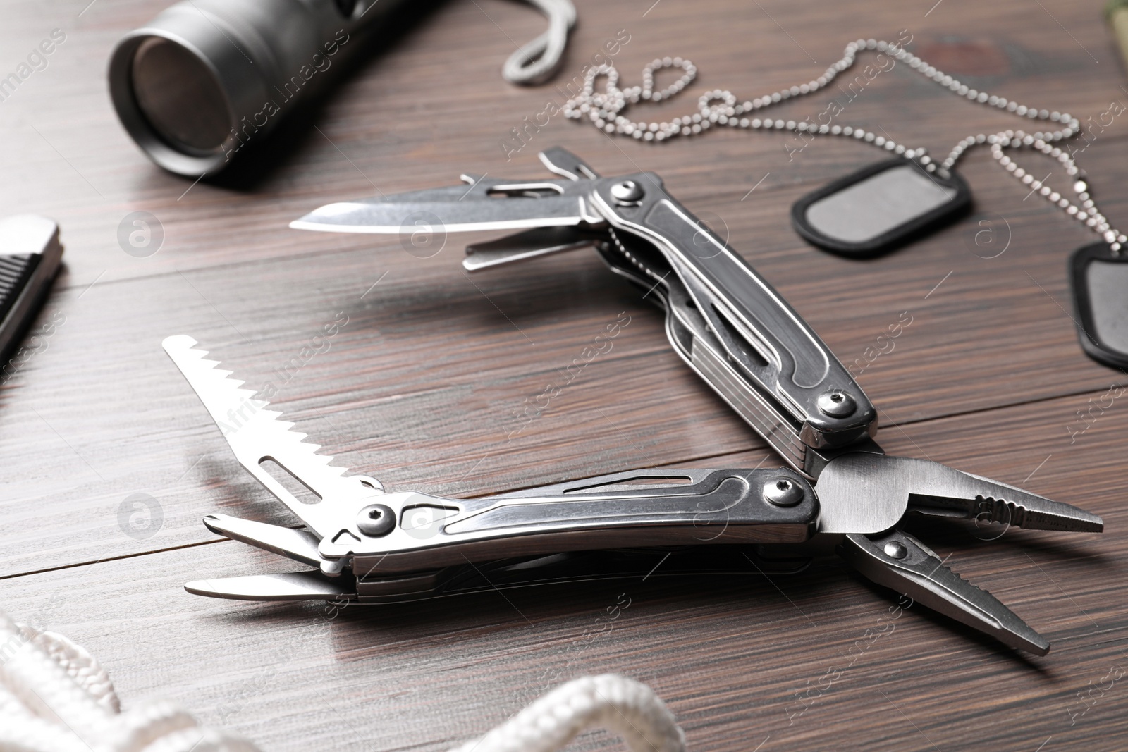 Photo of Modern compact portable multitool and accessories on wooden table