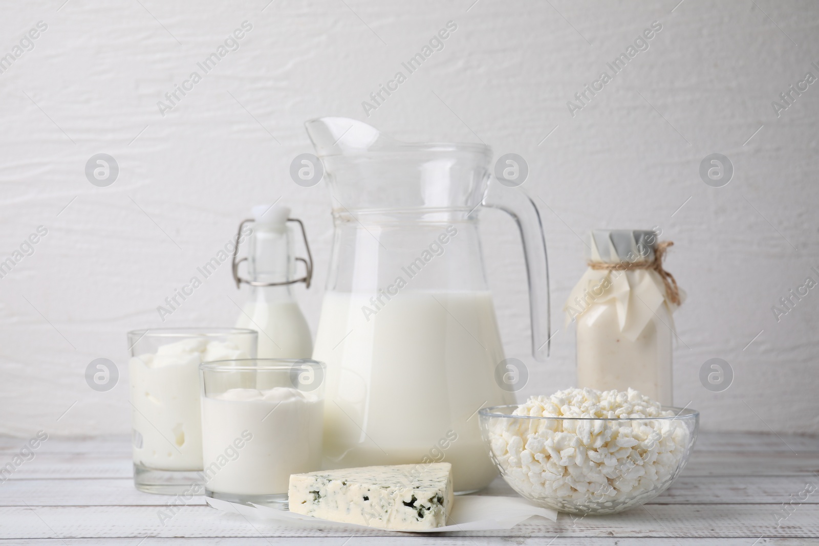 Photo of Different fresh dairy products on white wooden table