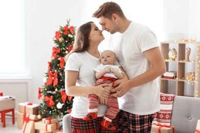 Happy couple with baby celebrating Christmas together at home