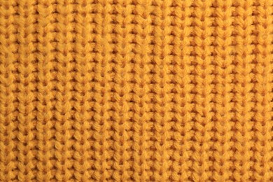 Photo of Beautiful orange knitted fabric as background, top view