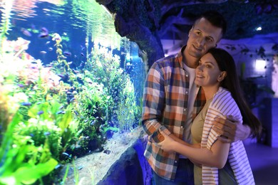 Image of Happy couple near aquarium in oceanarium. Spending time together