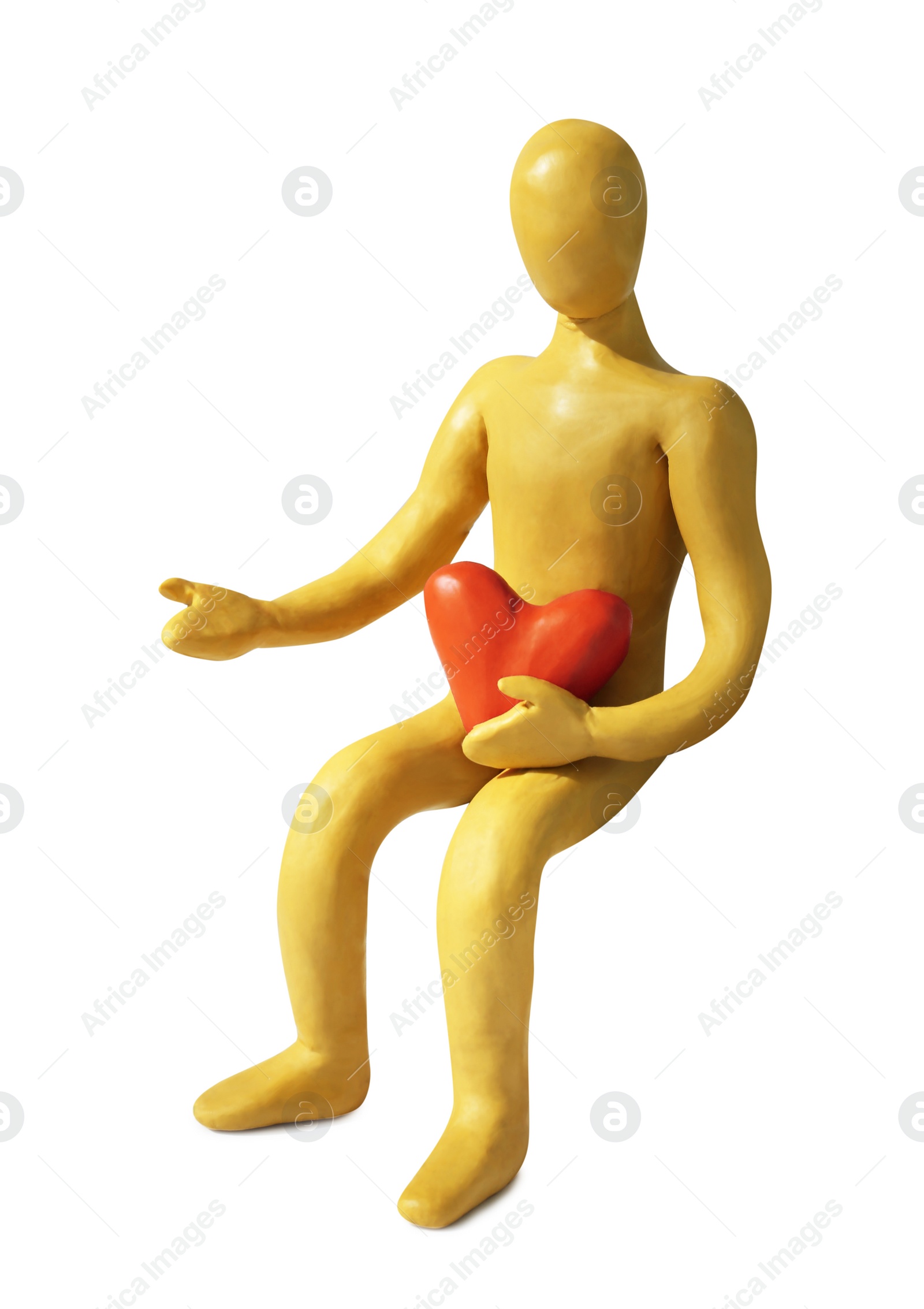Photo of Yellow plasticine human figure with pink heart isolated on white