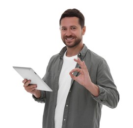 Happy man with tablet showing ok gesture on white background