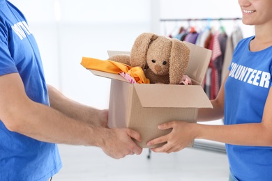 Young volunteers holding box with donations indoors, closeup