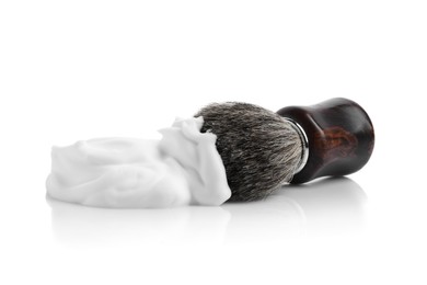 Photo of Shaving foam and brush on white background