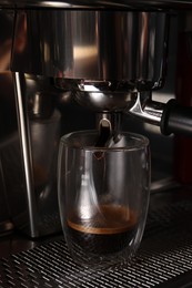Making fresh aromatic espresso using professional coffee machine in cafe