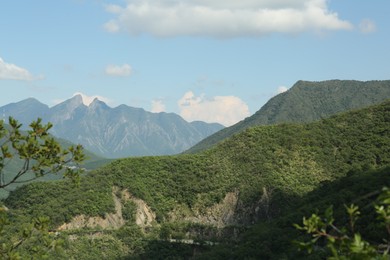 Photo of Picturesque view of big mountains and trees under cloudy sky