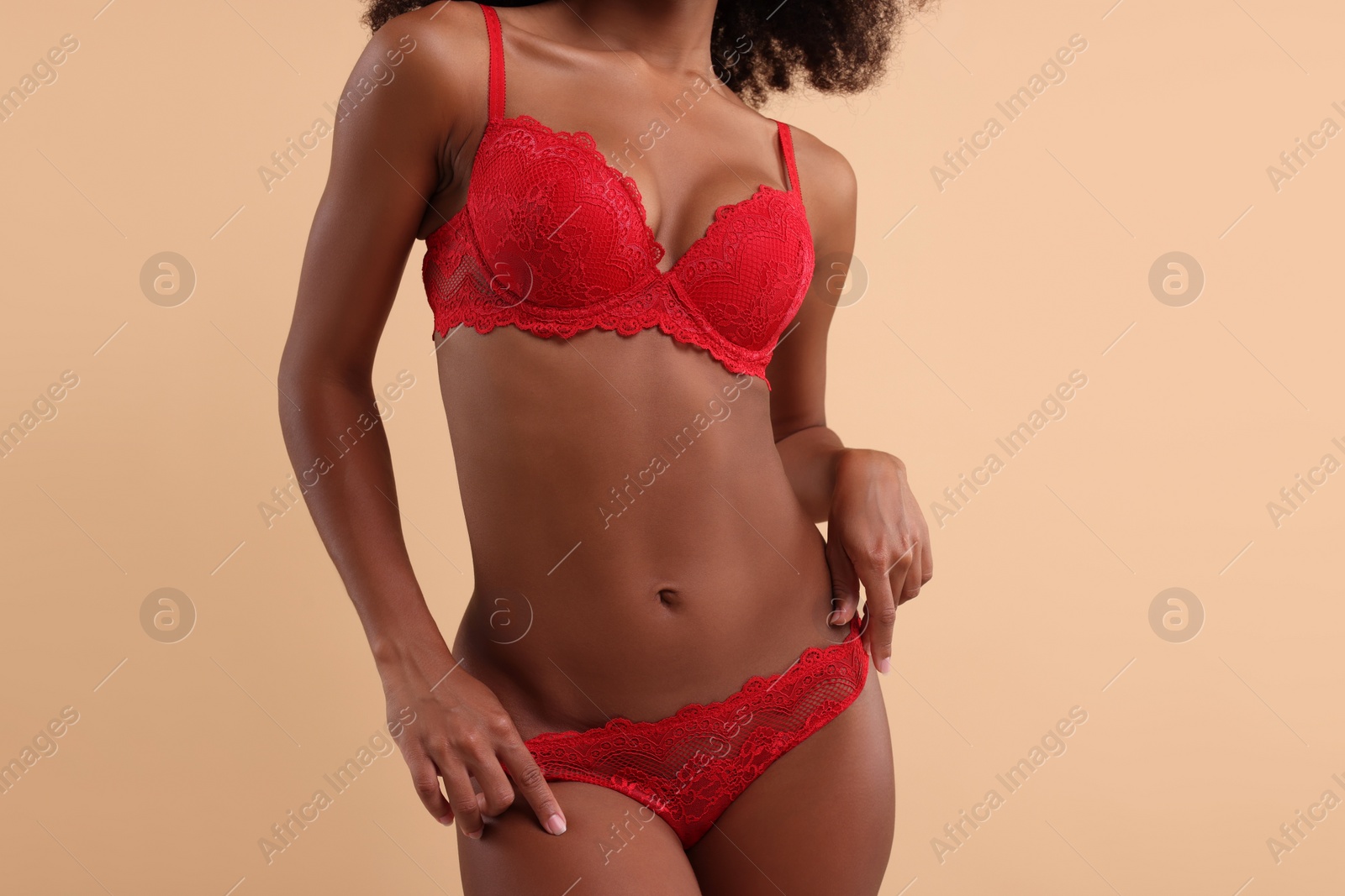Photo of Woman in elegant red underwear on beige background, closeup