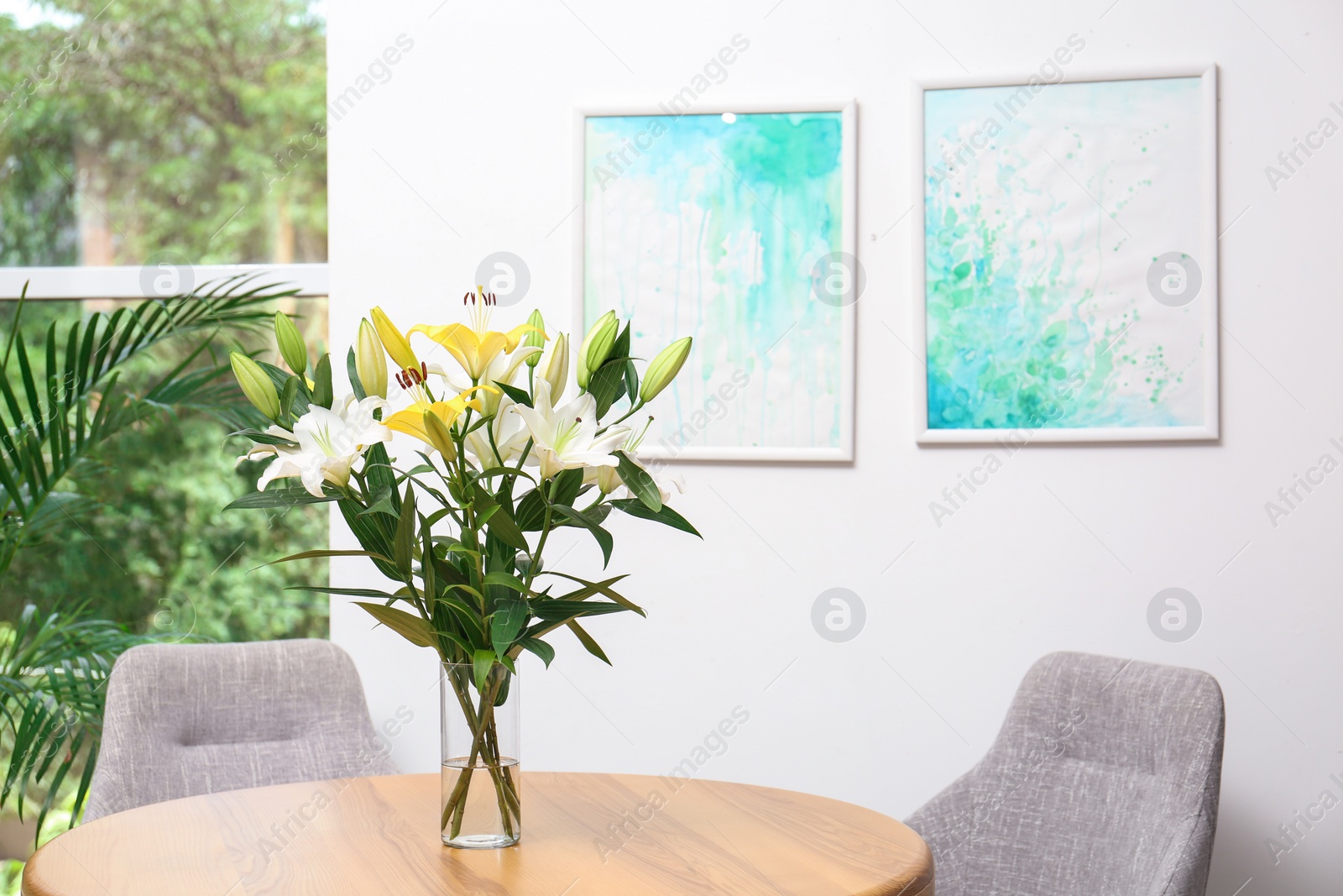 Photo of Vase with bouquet of beautiful lilies on wooden table indoors. Space for text