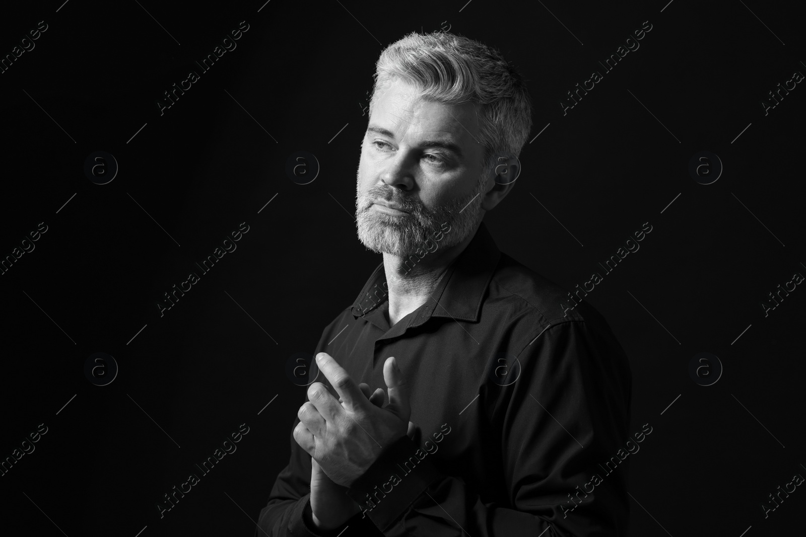 Photo of Portrait of handsome man on dark background. Black and white effect