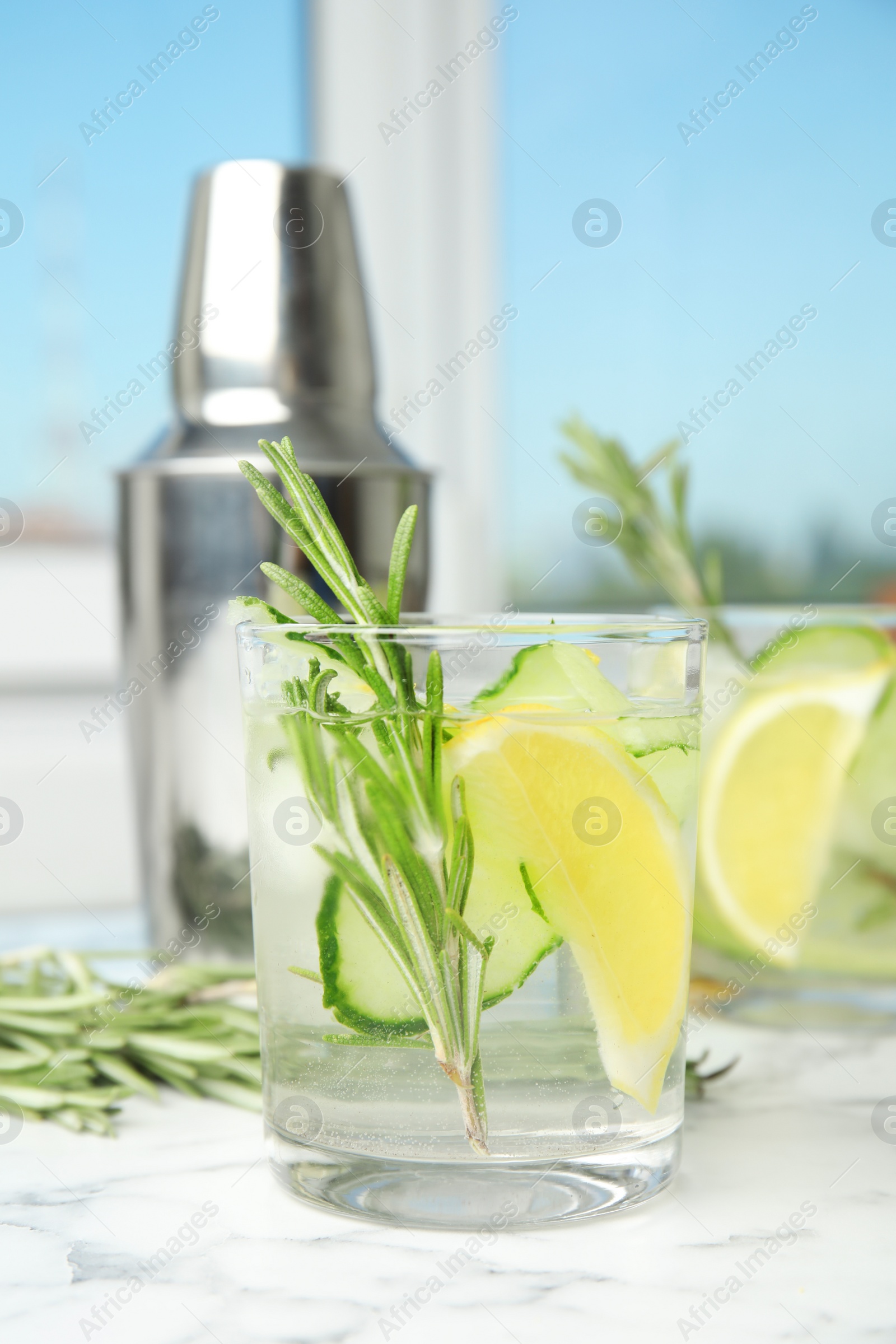 Photo of Refreshing lemon cocktail with rosemary on marble table