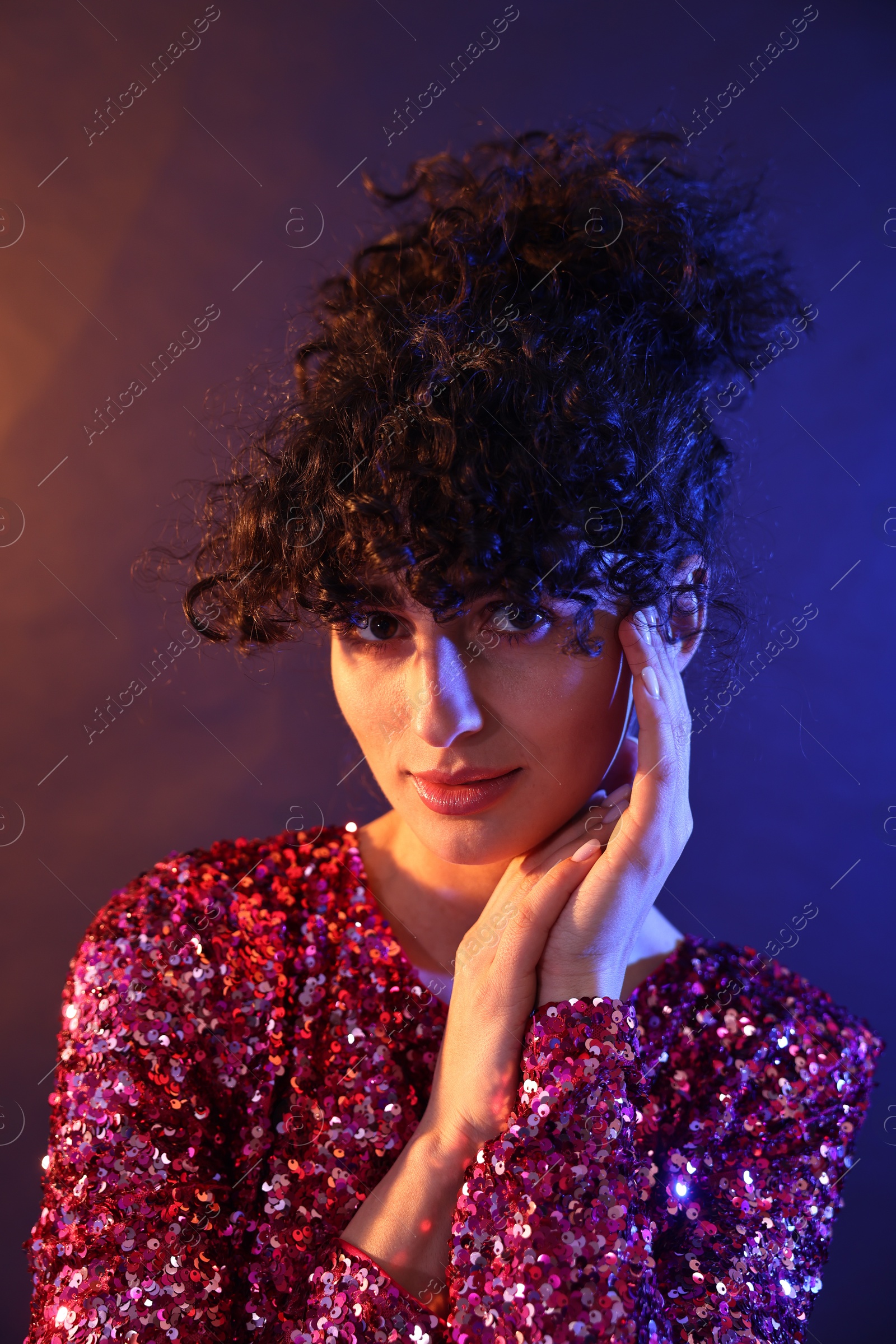 Photo of Beautiful young woman posing on color background in neon lights