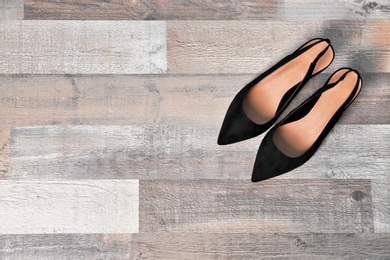 Pair of female shoes on wooden background, top view