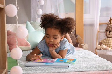 Photo of African American girl reading book at home