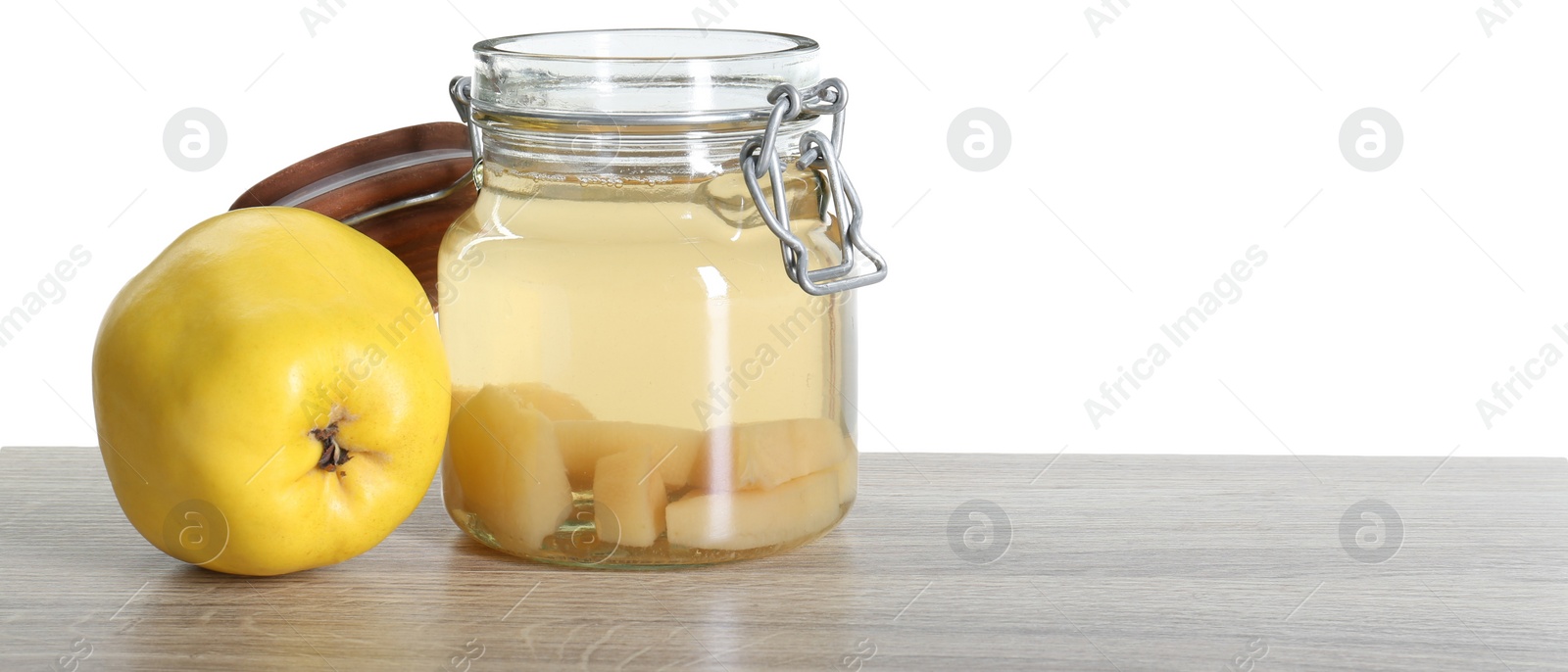 Photo of Delicious quince drink and fresh fruit on wooden table against white background