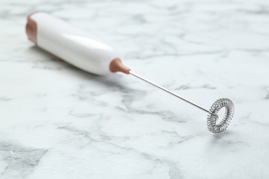 Photo of Milk frother wand on white marble table