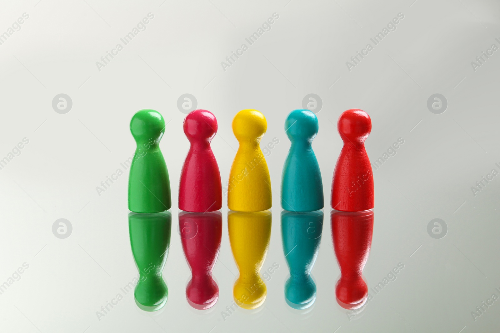 Photo of Colorful pawns on white background. Social inclusion concept