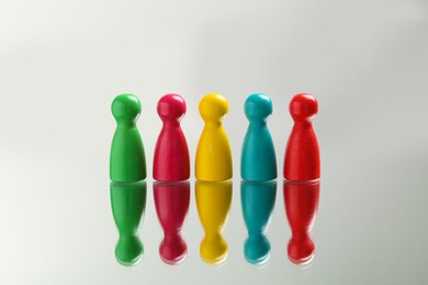 Photo of Colorful pawns on white background. Social inclusion concept