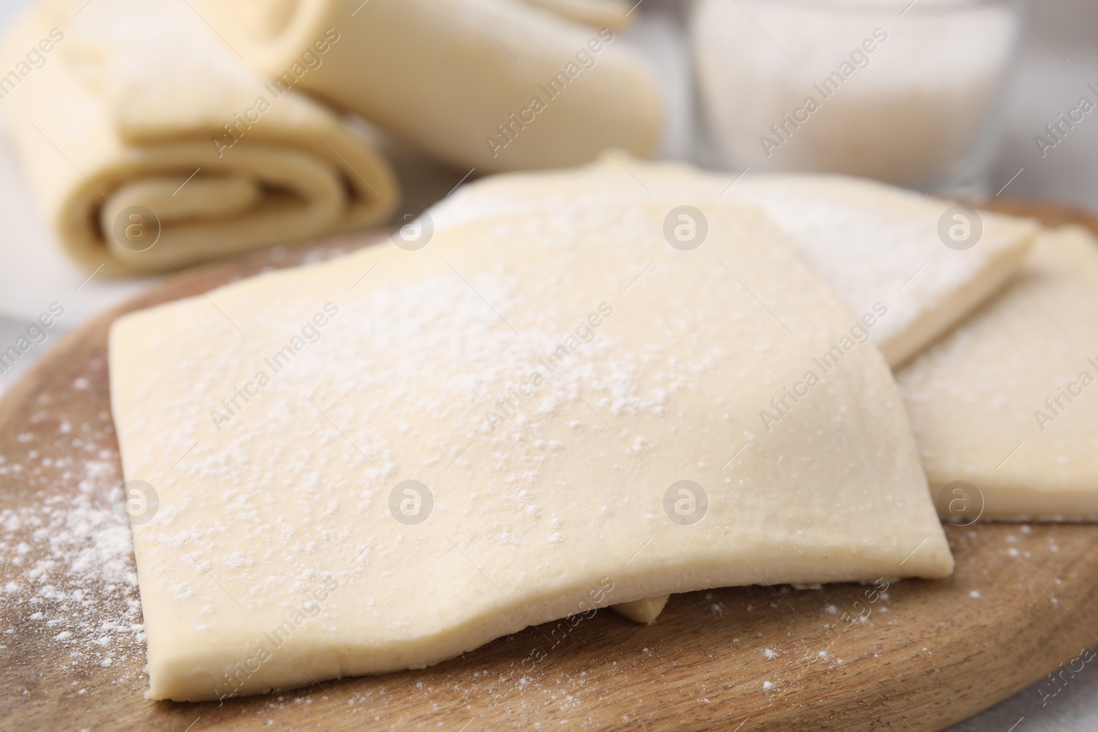 Photo of Raw puff pastry dough on table, closeup