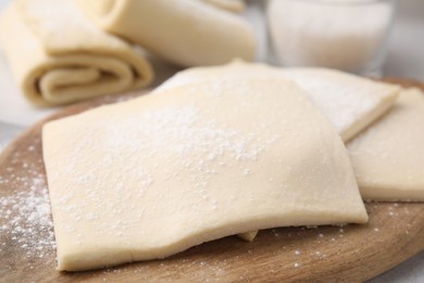 Photo of Raw puff pastry dough on table, closeup