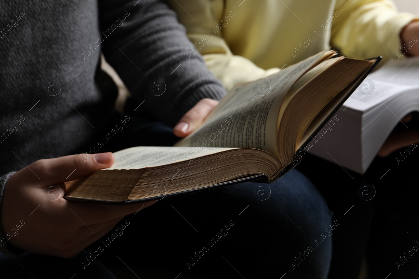 Photo of Couple sitting and reading holy Bibles, closeup