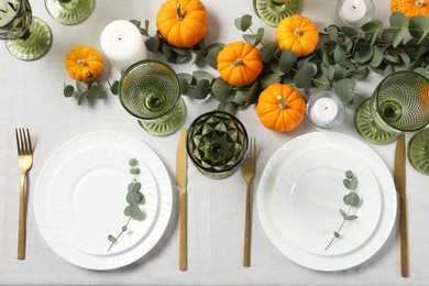 Beautiful autumn table setting. Plates, cutlery, glasses, pumpkins and floral decor, flat lay