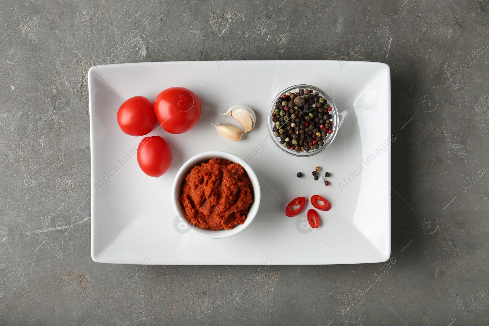 Photo of Red curry paste and ingredients on grey table, top view