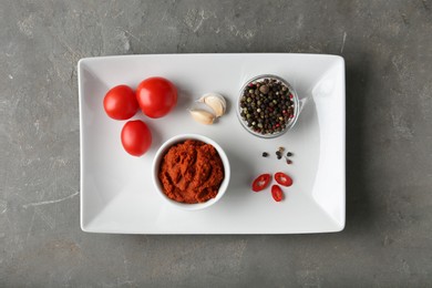 Photo of Red curry paste and ingredients on grey table, top view