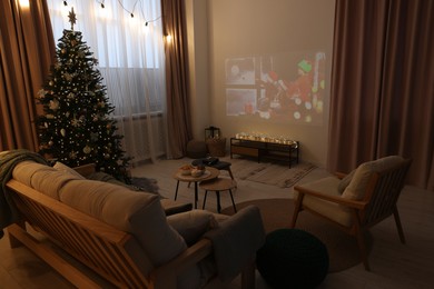 Photo of Video projector with Christmas movie in cosy room. Winter holidays atmosphere