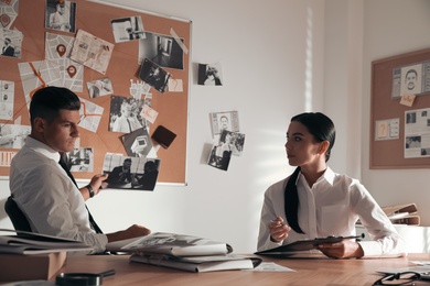 Professional detectives working at desk in office