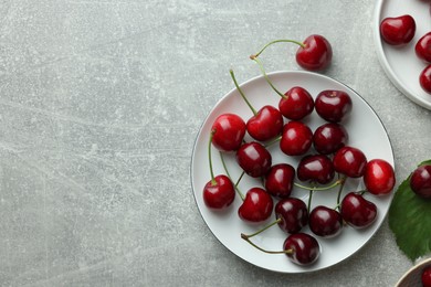 Fresh ripe cherries on light grey table, flat lay. Space for text