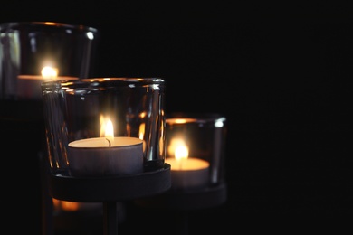 Photo of Burning candles on dark background. Funeral symbol