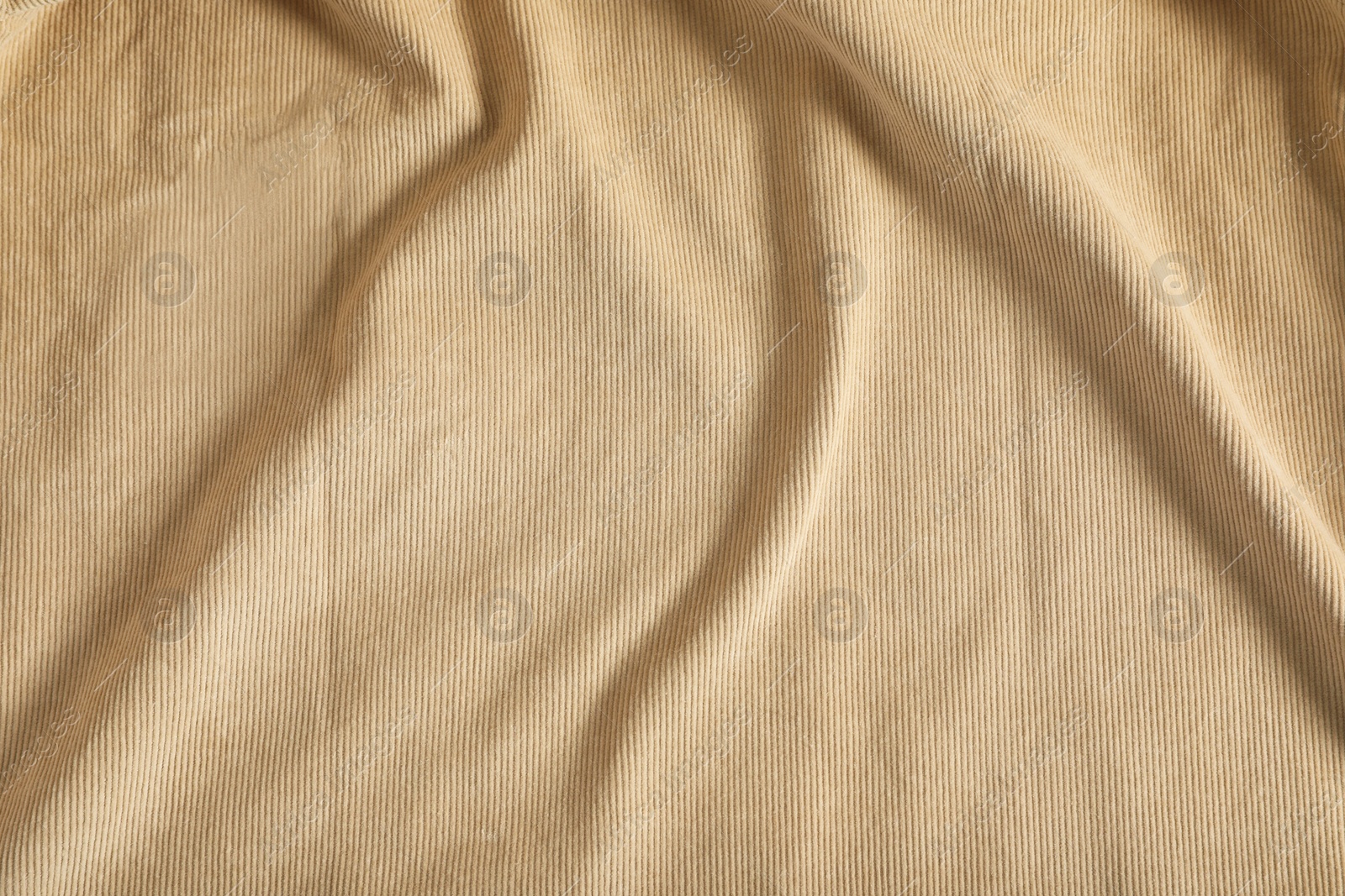 Photo of Crumpled beige fabric as background, top view