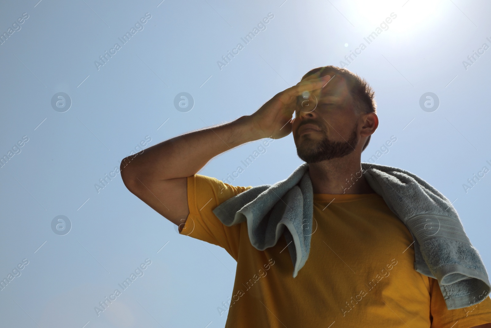 Photo of Man with towel suffering from heat stroke outdoors