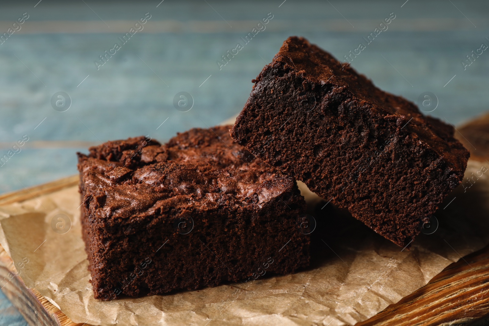 Photo of Wooden board with fresh brownies on table. Delicious chocolate pie