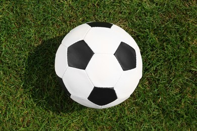 Photo of Football ball on green grass, top view