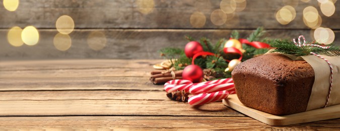 Image of Delicious gingerbread cake, candy canes and Christmas decor on wooden table, space for text. Banner design