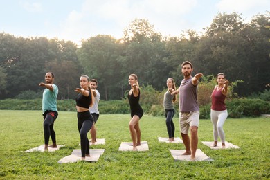 Photo of Group of people practicing yoga on mats outdoors