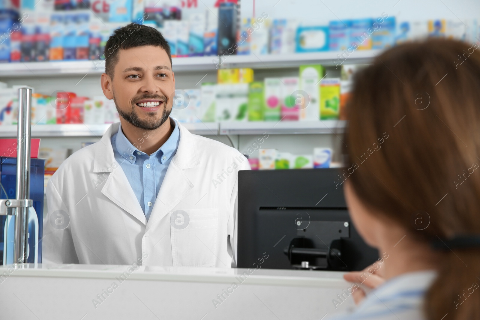 Photo of Professional pharmacist working with customer in drugstore