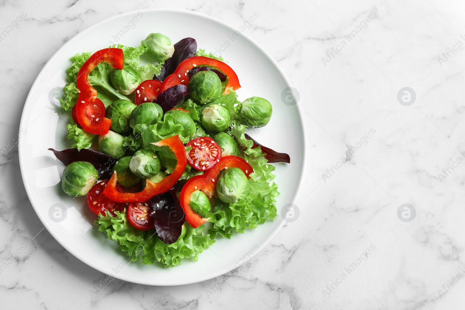 Photo of Tasty salad with Brussels sprouts on white marble table, top view. Space for text