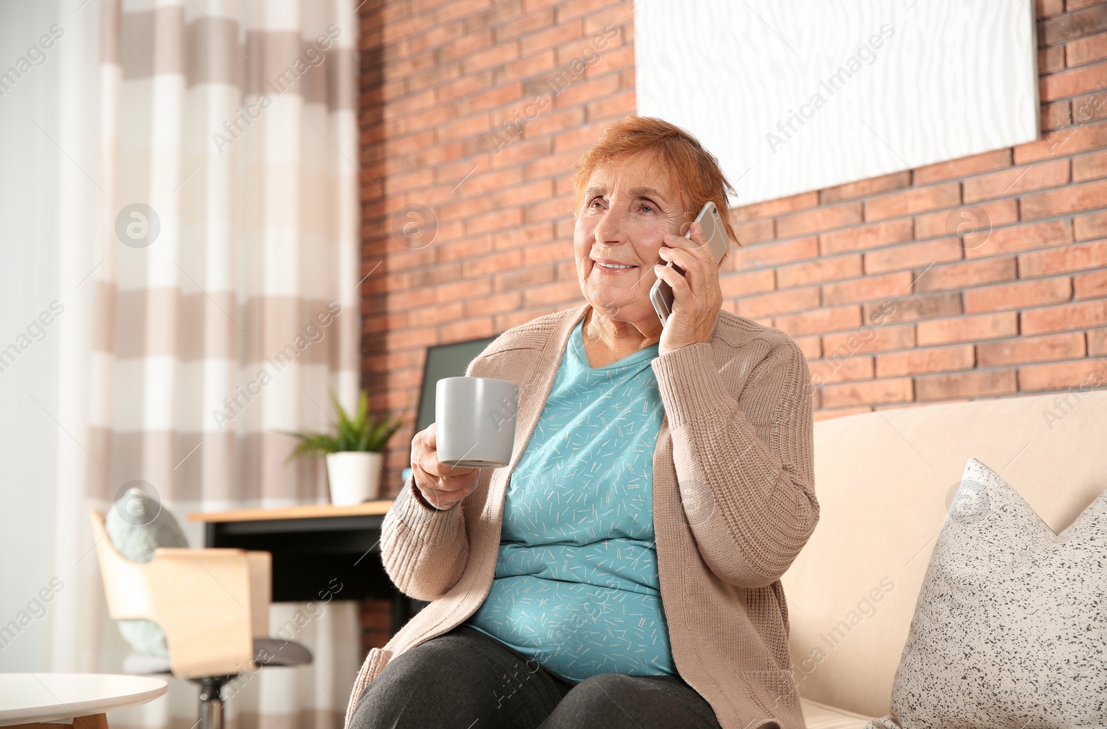 Photo of Elderly woman talking on phone in living room