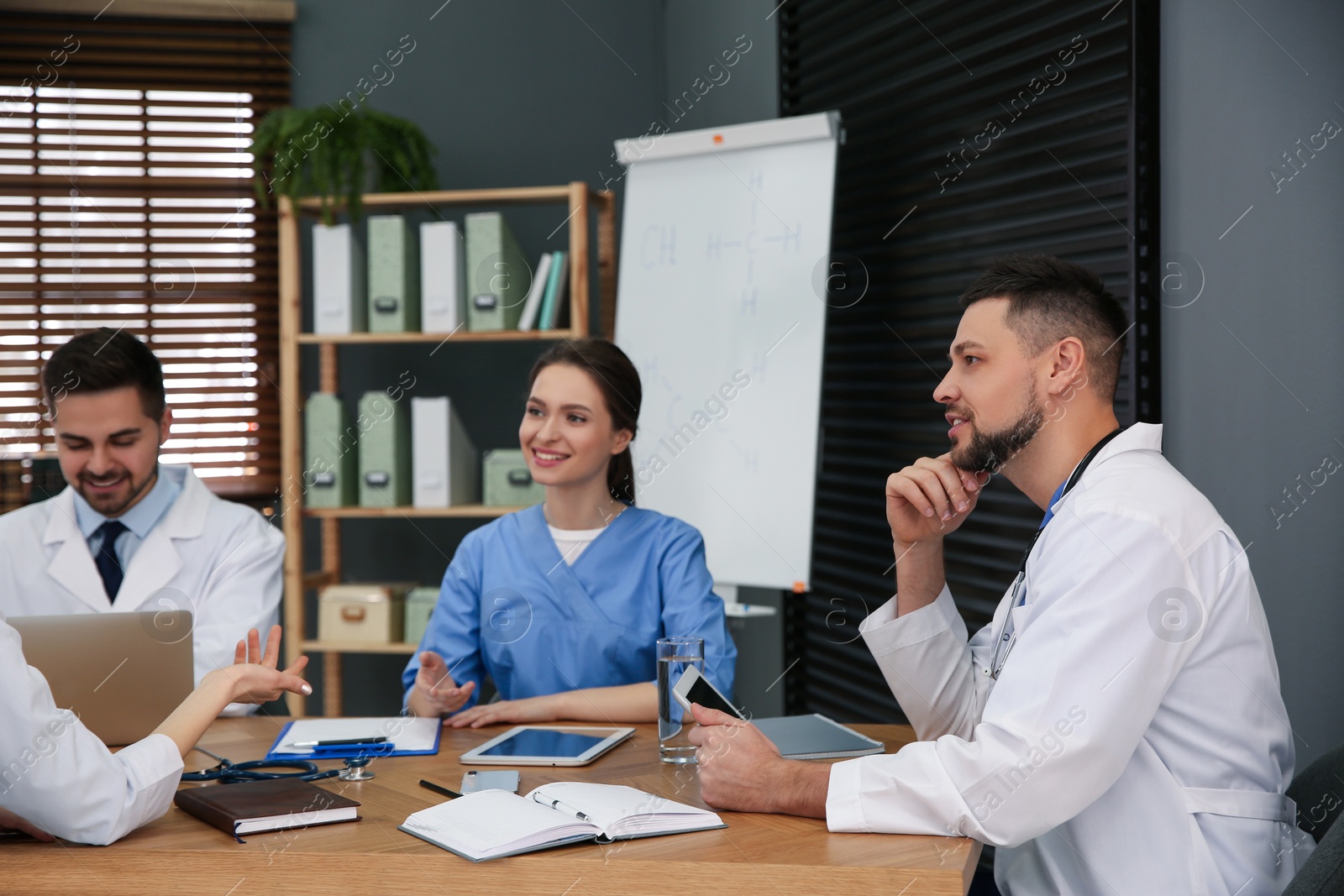 Photo of Team of professional doctors having meeting in office