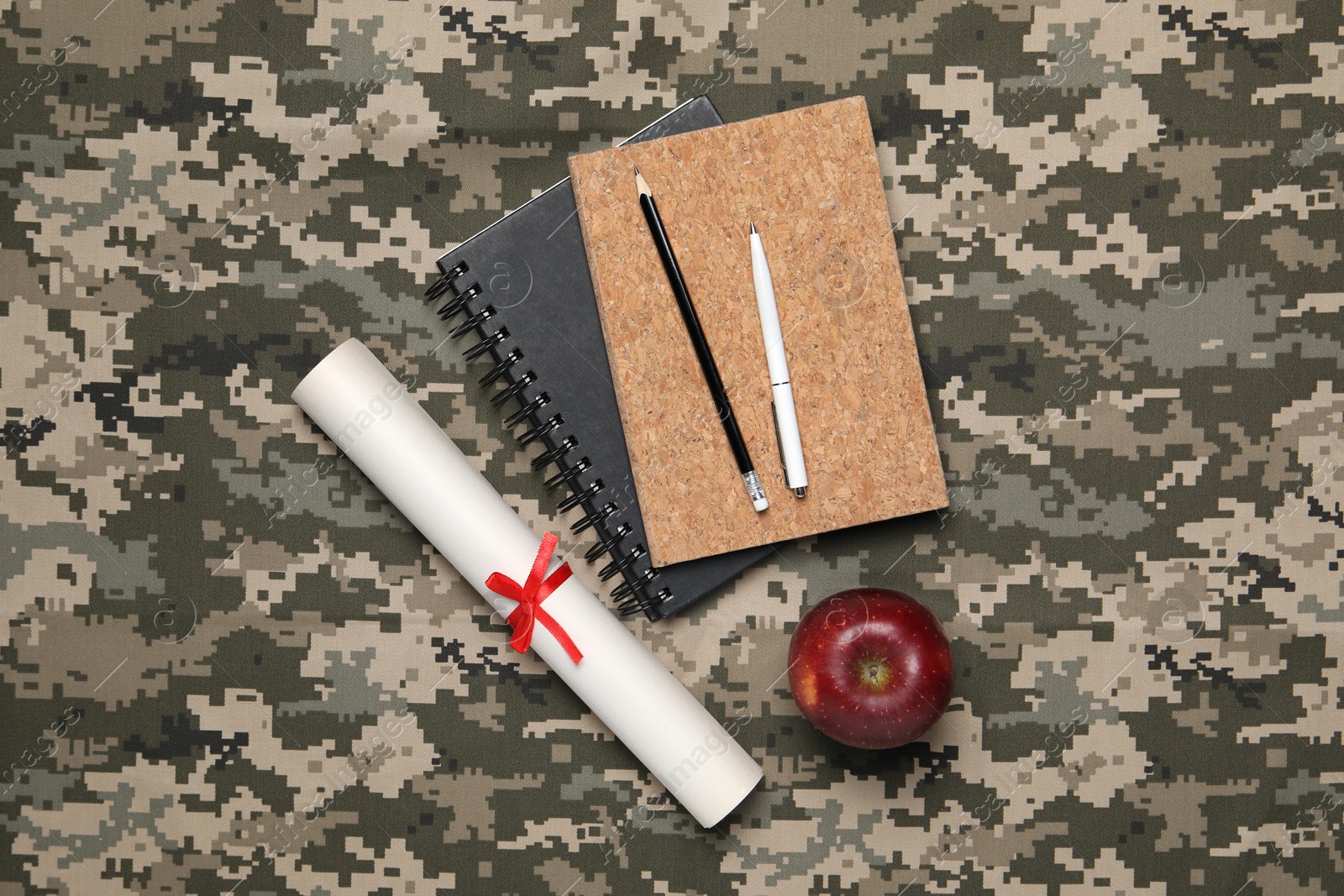 Photo of Diploma, stationery and apple on camouflage background, flat lay. Military education