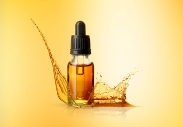 Image of Bottle of cosmetic product with essential oil and splashes around on gold gradient background