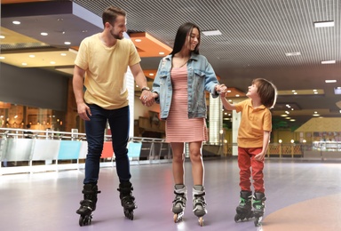 Happy family spending time at roller skating rink