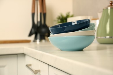 Photo of Set of clean color bowls on white countertop in kitchen