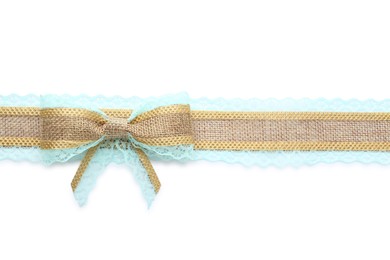 Burlap ribbon and bow with light blue lace on white background, top view