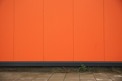 Photo of Beautiful orange wall and stone pavement outdoors