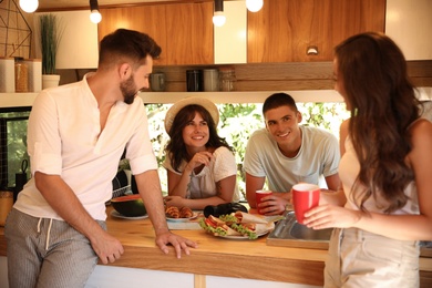 Photo of Happy young people having breakfast in trailer. Camping vacation