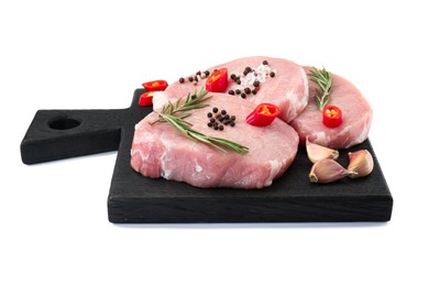 Photo of Black wooden board with pieces of raw pork meat and spices isolated on white